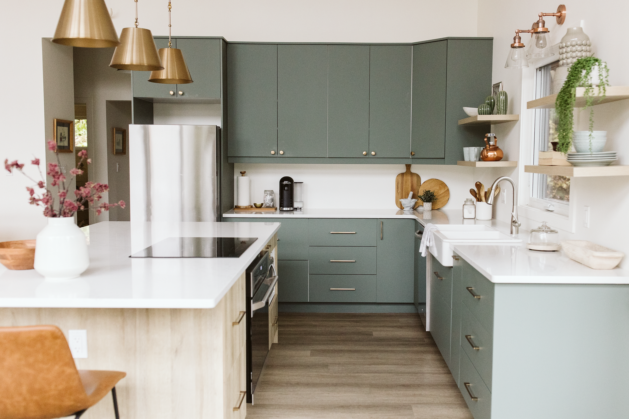 Modern kitchen with Sage cabinets, white countertops, and stainless steel appliances.