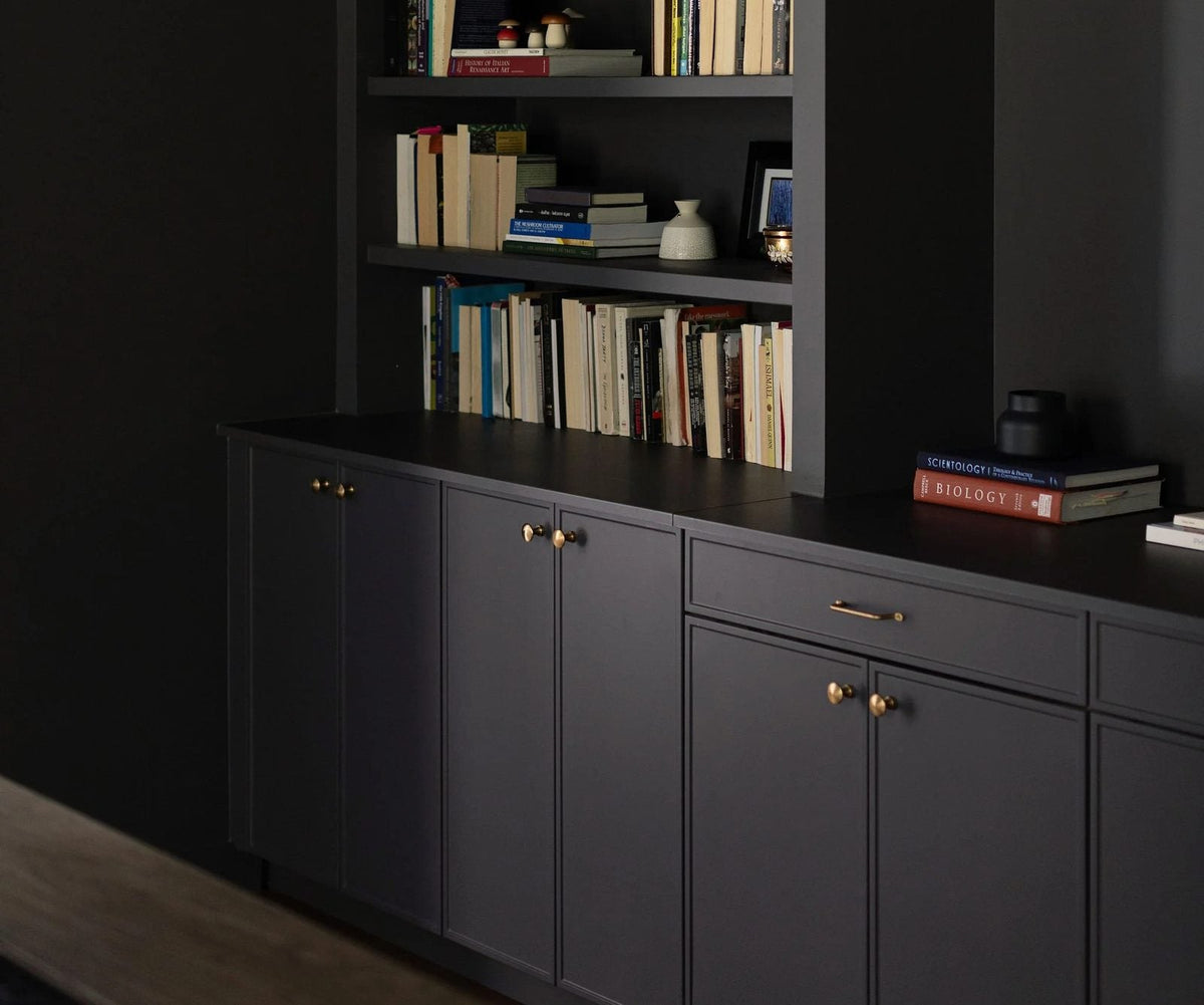 Deep navy shaker cabinet doors and drawers with brass knobs and bar pulls